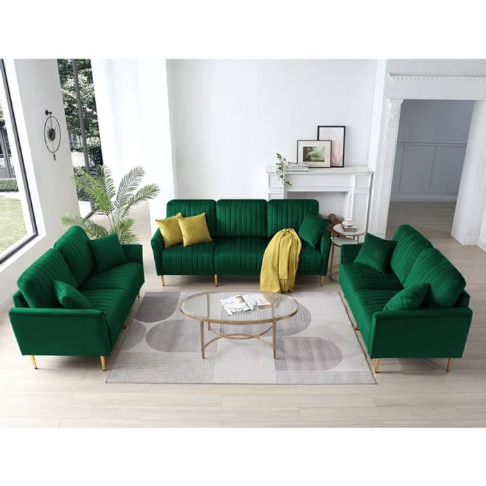 Green sofa set in a living room with a coffee table and decor items.
